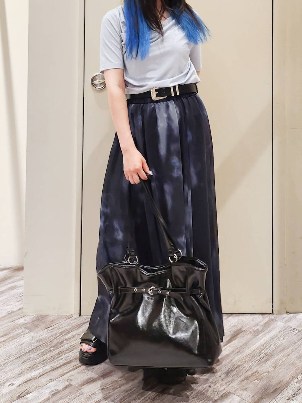 ブラック系のスカート、ブラック系のサンダル、グレー系のTシャツ/カットソーを着用したレディースの秋コーディネートの6枚目の写真