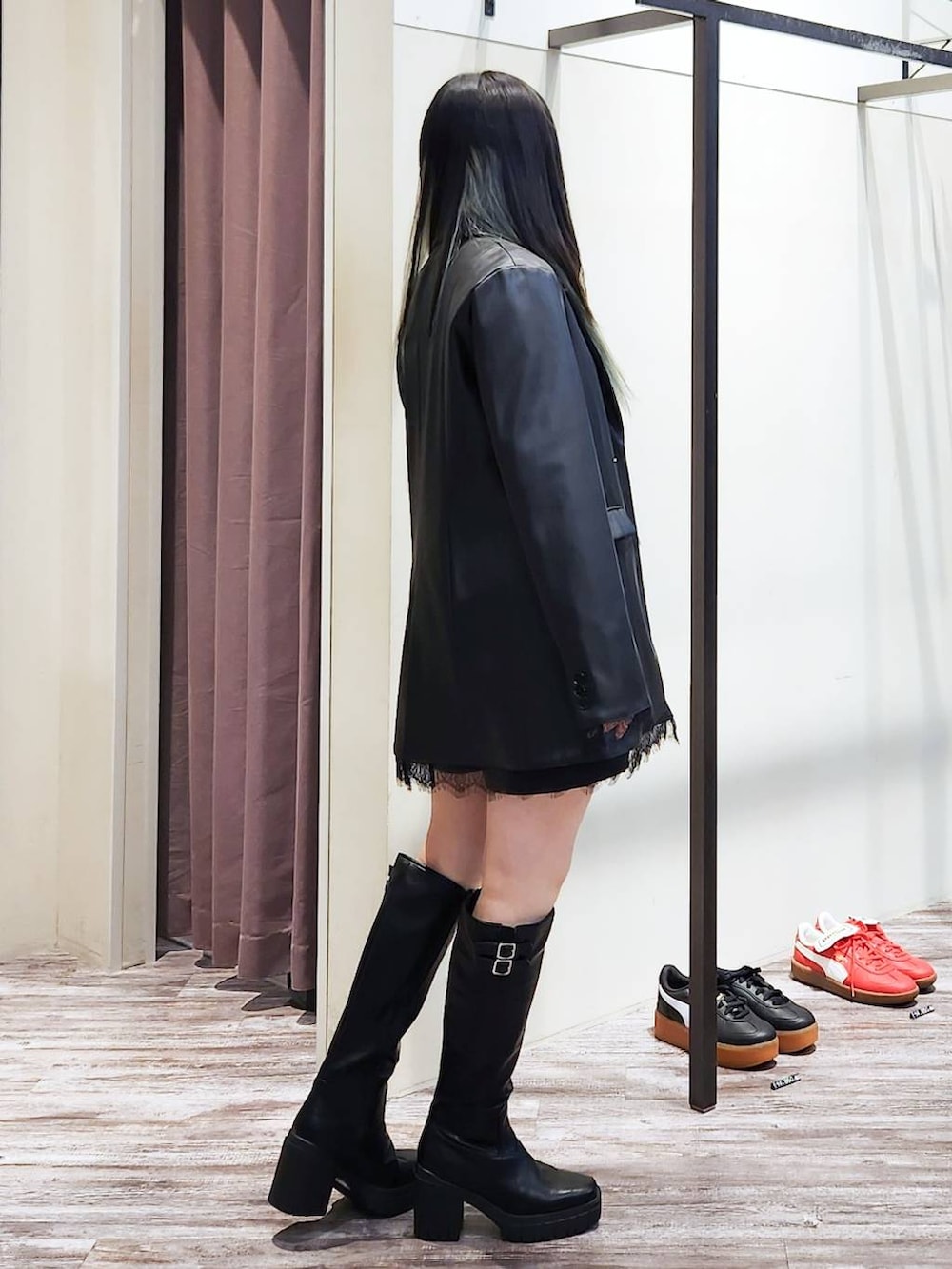 ブラック系のテーラードジャケット、ブラック系のニット/セーター、ブラック系のブーツを着用したレディースの秋コーディネートの3枚目の写真