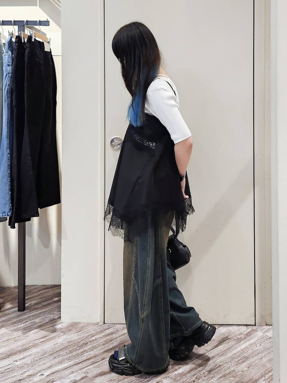 ブラック系のキャミソール、グリーン系のデニムパンツ、グレー系のサンダルを着用したレディースの秋コーディネートの5枚目の写真