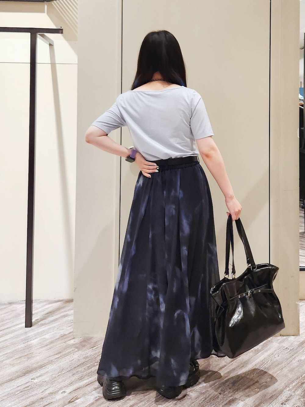ブラック系のスカート、ブラック系のサンダル、グレー系のTシャツ/カットソーを着用したレディースの秋コーディネートの4枚目の写真