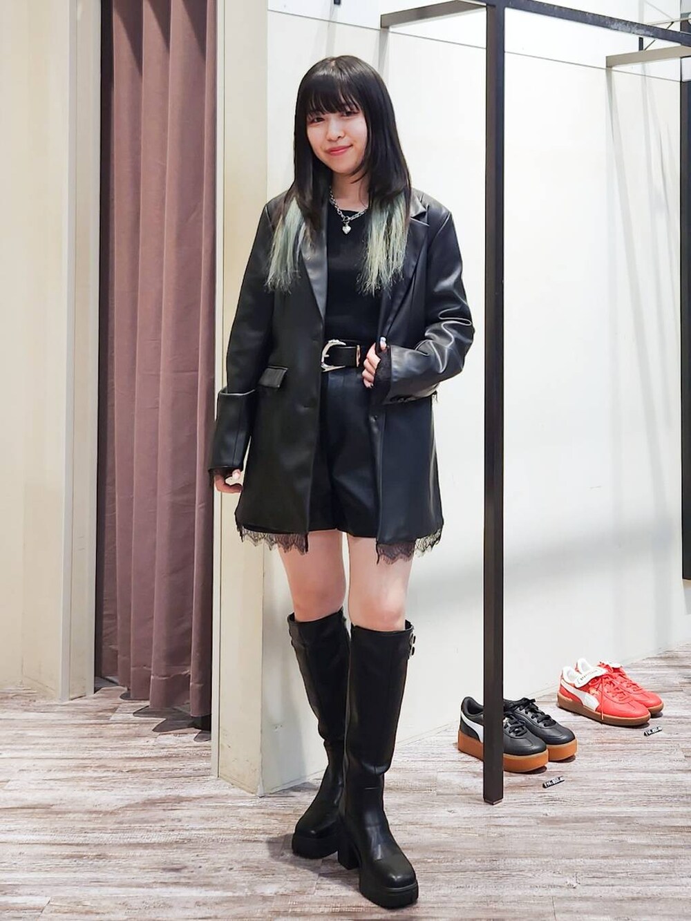 ブラック系のテーラードジャケット、ブラック系のニット/セーター、ブラック系のブーツを着用したレディースの秋コーディネートの6枚目の写真