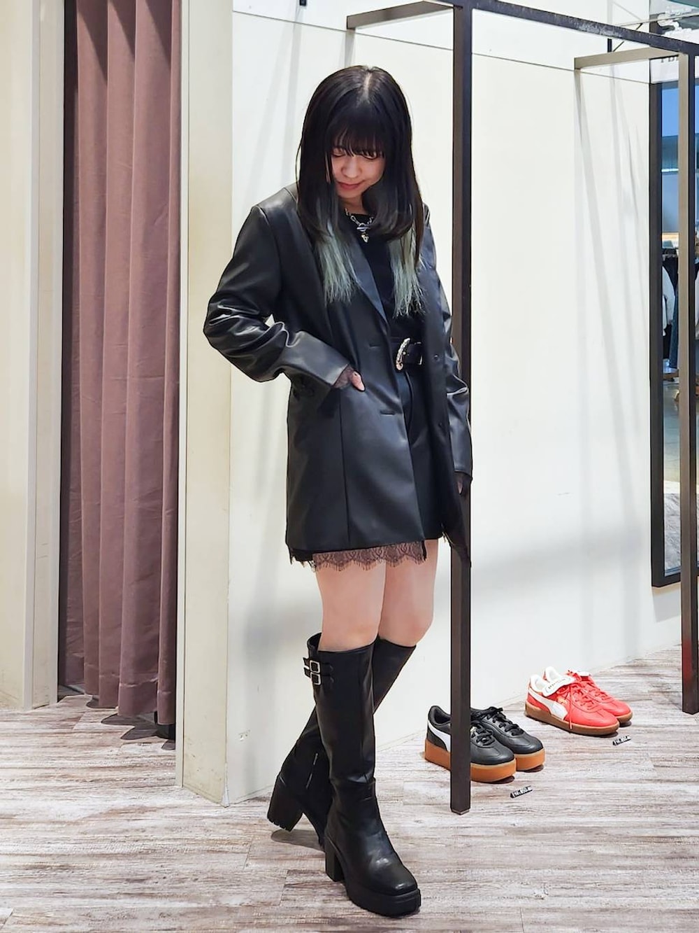 ブラック系のテーラードジャケット、ブラック系のニット/セーター、ブラック系のブーツを着用したレディースの秋コーディネートの2枚目の写真