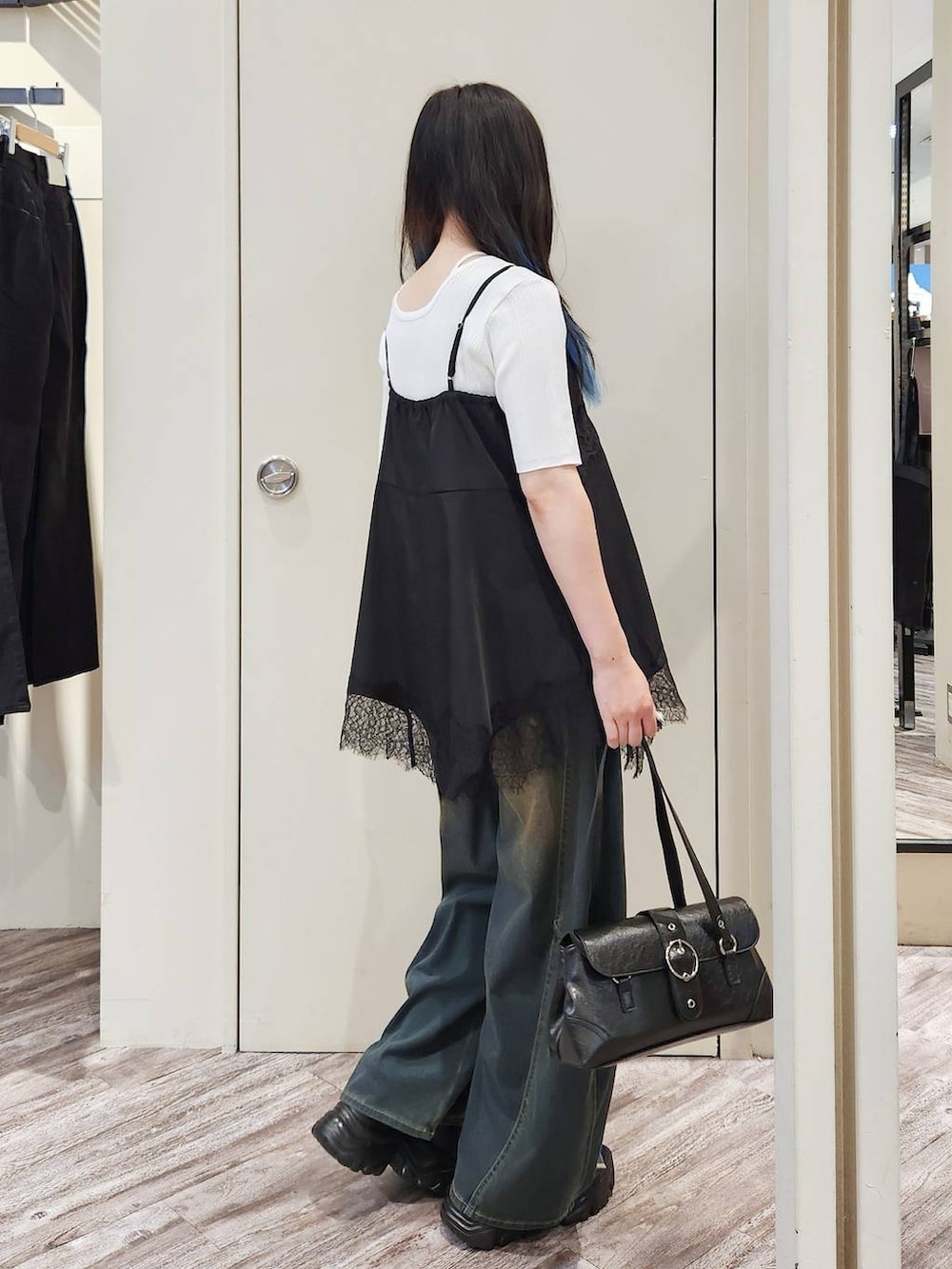 ブラック系のキャミソール、グリーン系のデニムパンツ、グレー系のサンダルを着用したレディースの秋コーディネートの3枚目の写真