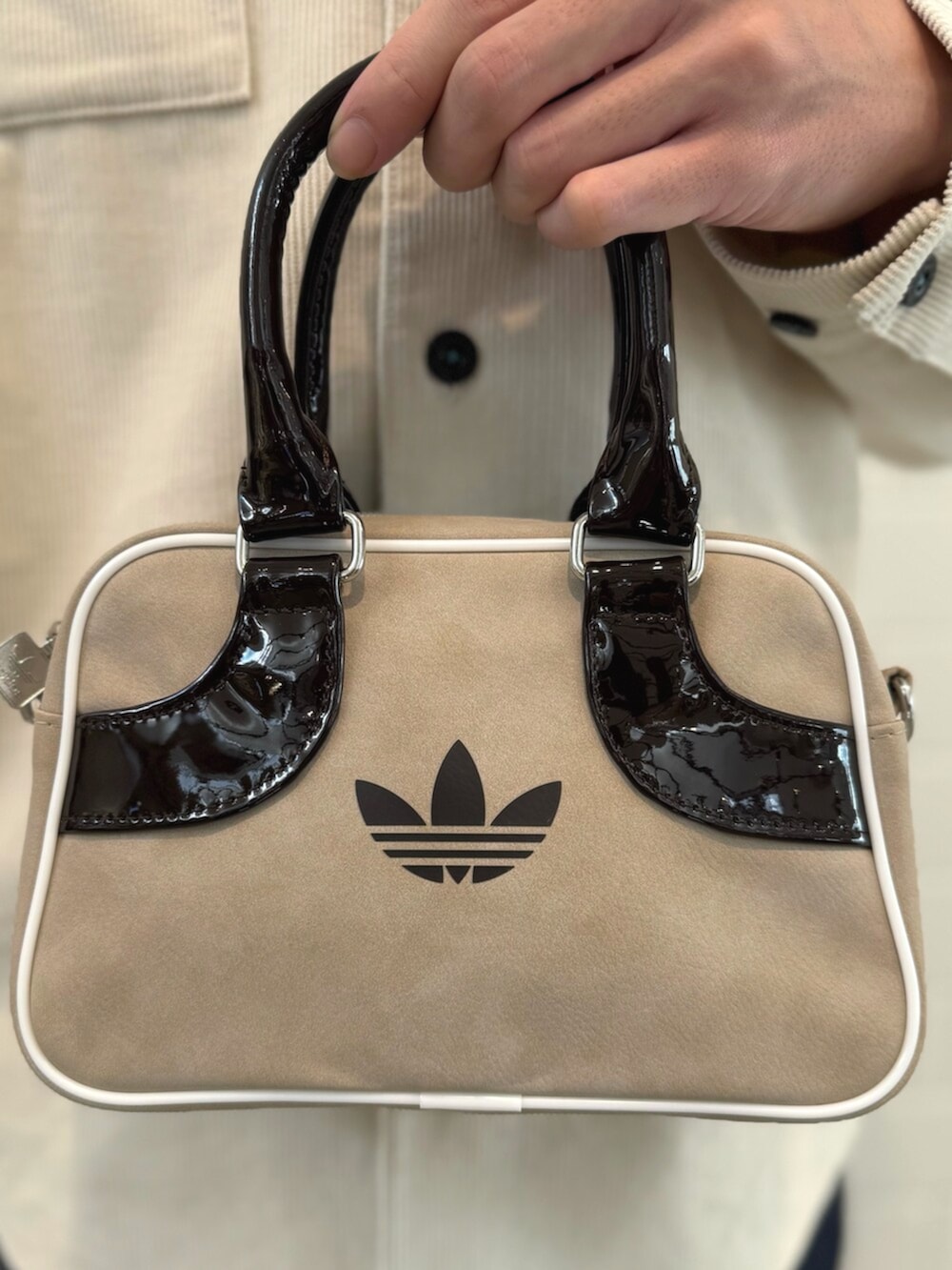 ベージュ系のスニーカー、ホワイト系のTシャツ/カットソー、ベージュ系のショルダーバッグを着用したメンズの秋コーディネートの5枚目の写真