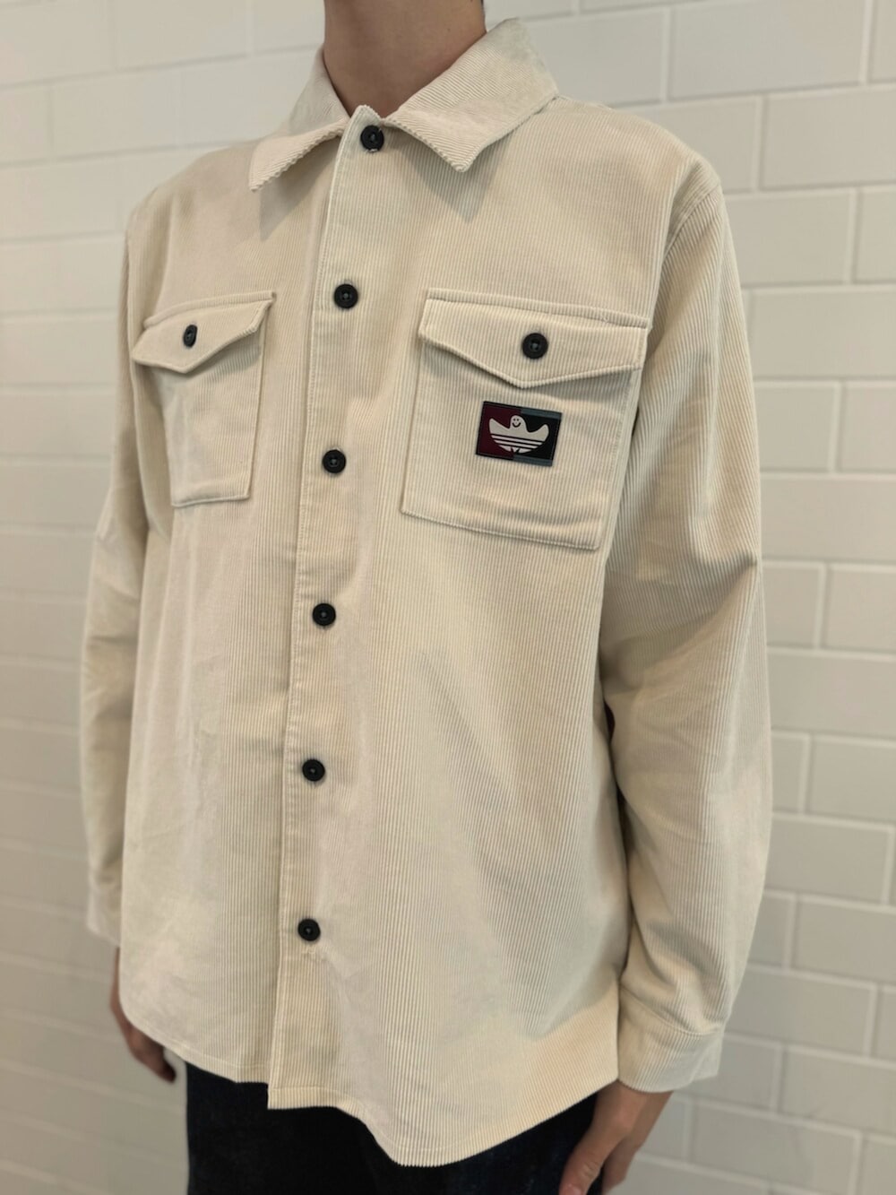 ベージュ系のスニーカー、ホワイト系のTシャツ/カットソー、ベージュ系のショルダーバッグを着用したメンズの秋コーディネートの4枚目の写真