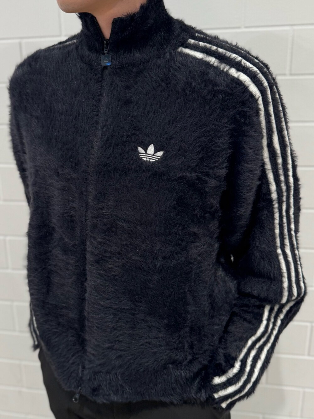 イエロー系のスニーカー、ブラック系のジャージを着用したメンズの秋コーディネートの3枚目の写真