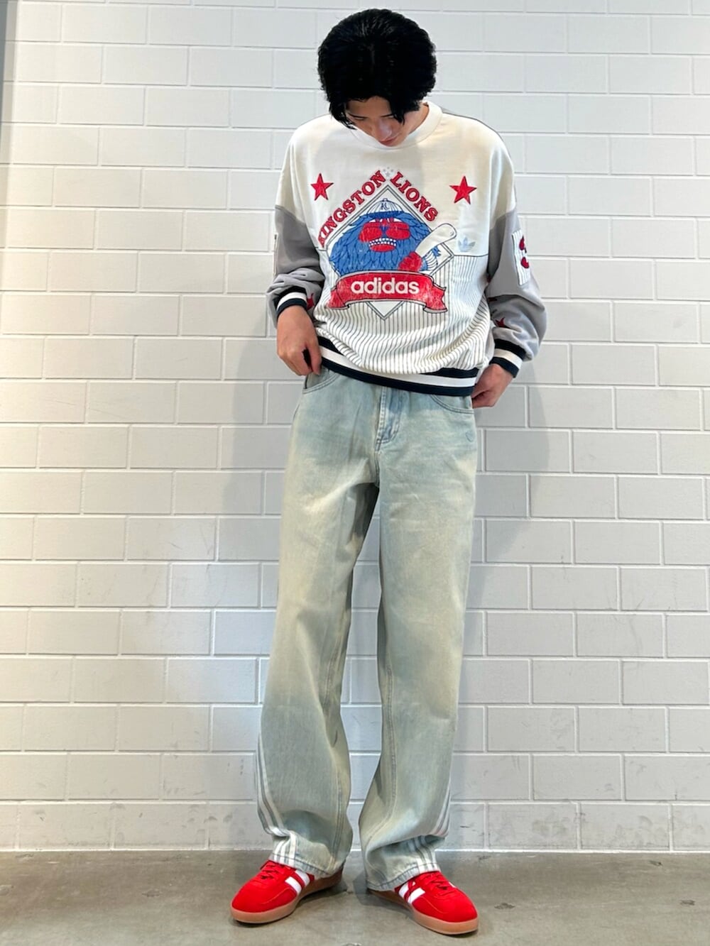 レッド系のシューズ、ブルー系のデニムパンツ、グレー系のスウェットを着用したメンズの秋コーディネートの3枚目の写真