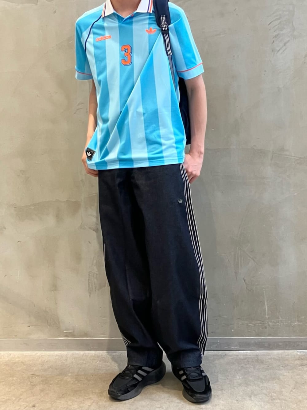 ブルー系のデニムパンツ、ブラック系のスニーカー、ブルー系のTシャツ/カットソーを着用したメンズの夏コーディネートの2枚目の写真