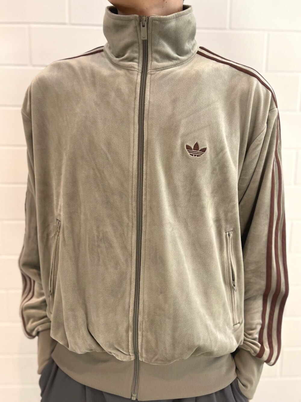 ベージュ系のジャージ、レッド系のシューズを着用したメンズの秋コーディネートの3枚目の写真