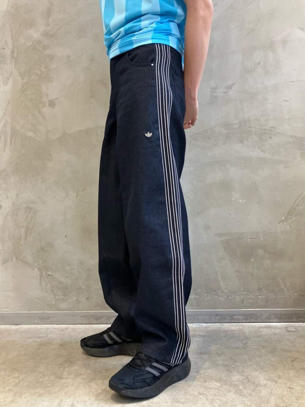 ブルー系のデニムパンツ、ブラック系のスニーカー、ブルー系のTシャツ/カットソーを着用したメンズの夏コーディネートの7枚目の写真