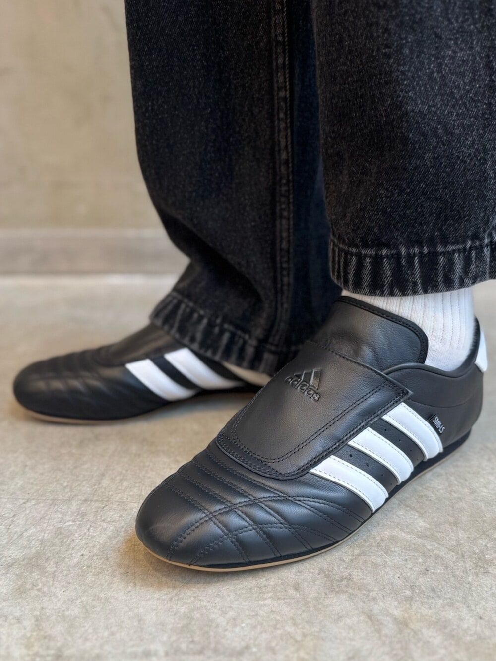 ブラック系のカーディガン/ボレロ、ブラック系のジャージ、ブラック系のデニムパンツを着用したメンズの冬コーディネートの6枚目の写真