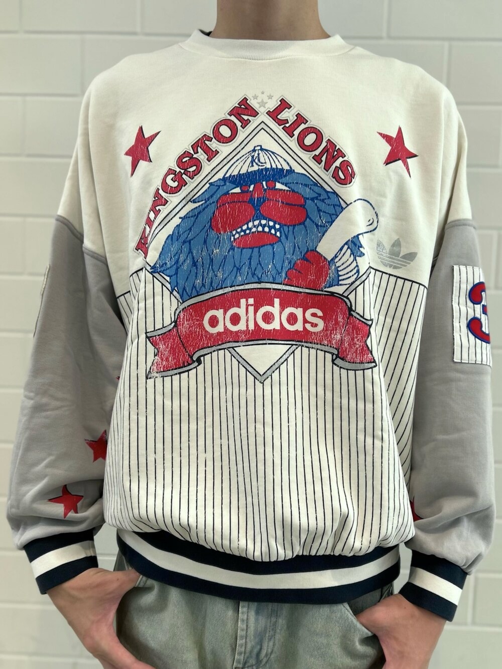 レッド系のシューズ、ブルー系のデニムパンツ、グレー系のスウェットを着用したメンズの秋コーディネートの4枚目の写真