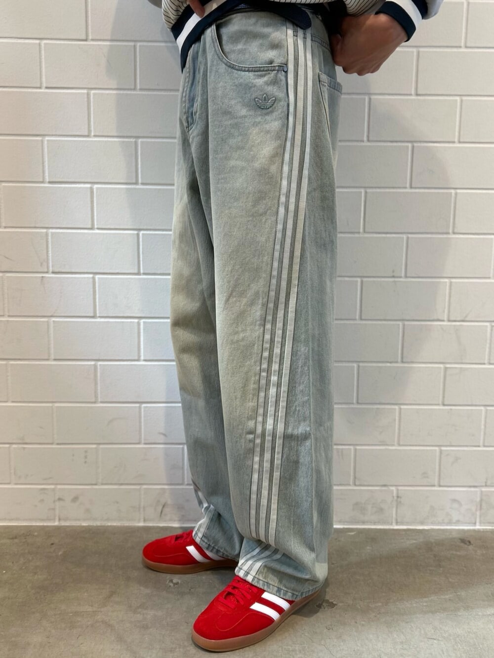 レッド系のシューズ、ブルー系のデニムパンツ、グレー系のスウェットを着用したメンズの秋コーディネートの5枚目の写真