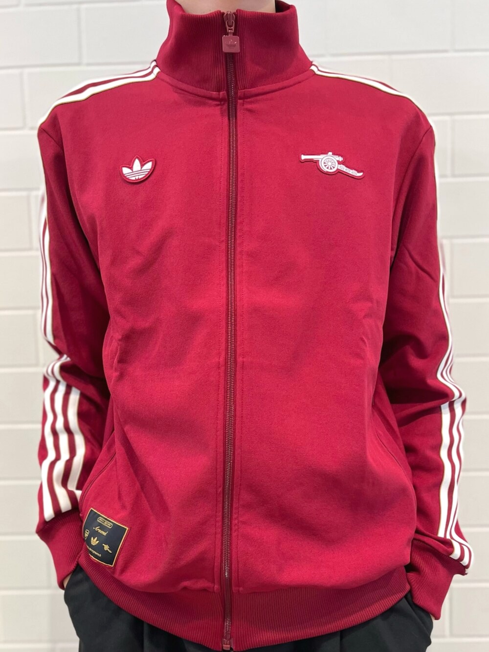 レッド系のジャージ、ホワイト系のポロシャツ、ブラウン系のスニーカーを着用したメンズの秋コーディネートの4枚目の写真