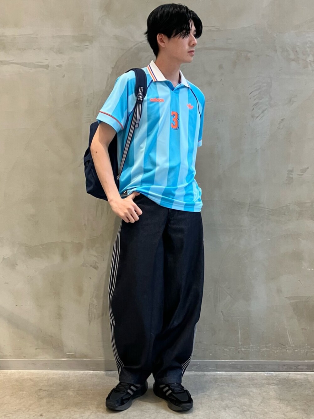 ブルー系のデニムパンツ、ブラック系のスニーカー、ブルー系のTシャツ/カットソーを着用したメンズの夏コーディネートの3枚目の写真