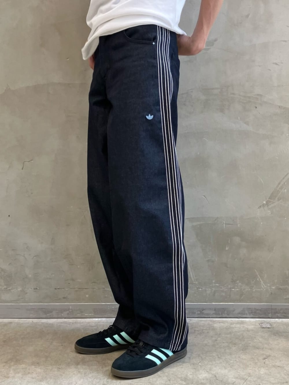 ブラック系のショルダーバッグ、ブルー系のデニムパンツ、ブラック系のスニーカーを着用したメンズの夏コーディネートの5枚目の写真