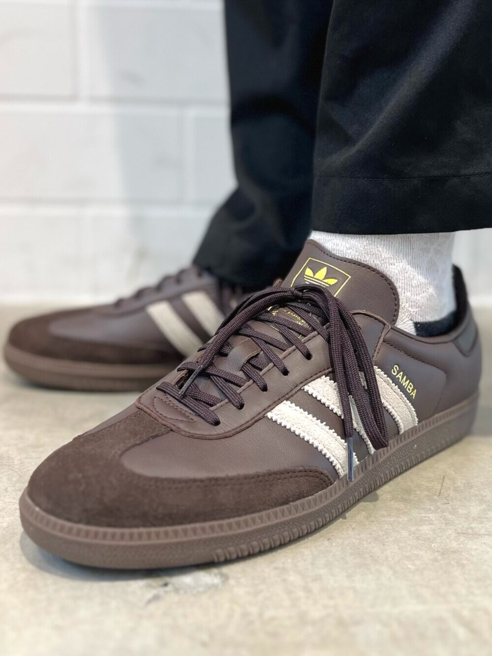 レッド系のジャージ、ホワイト系のポロシャツ、ブラウン系のスニーカーを着用したメンズの秋コーディネートの6枚目の写真