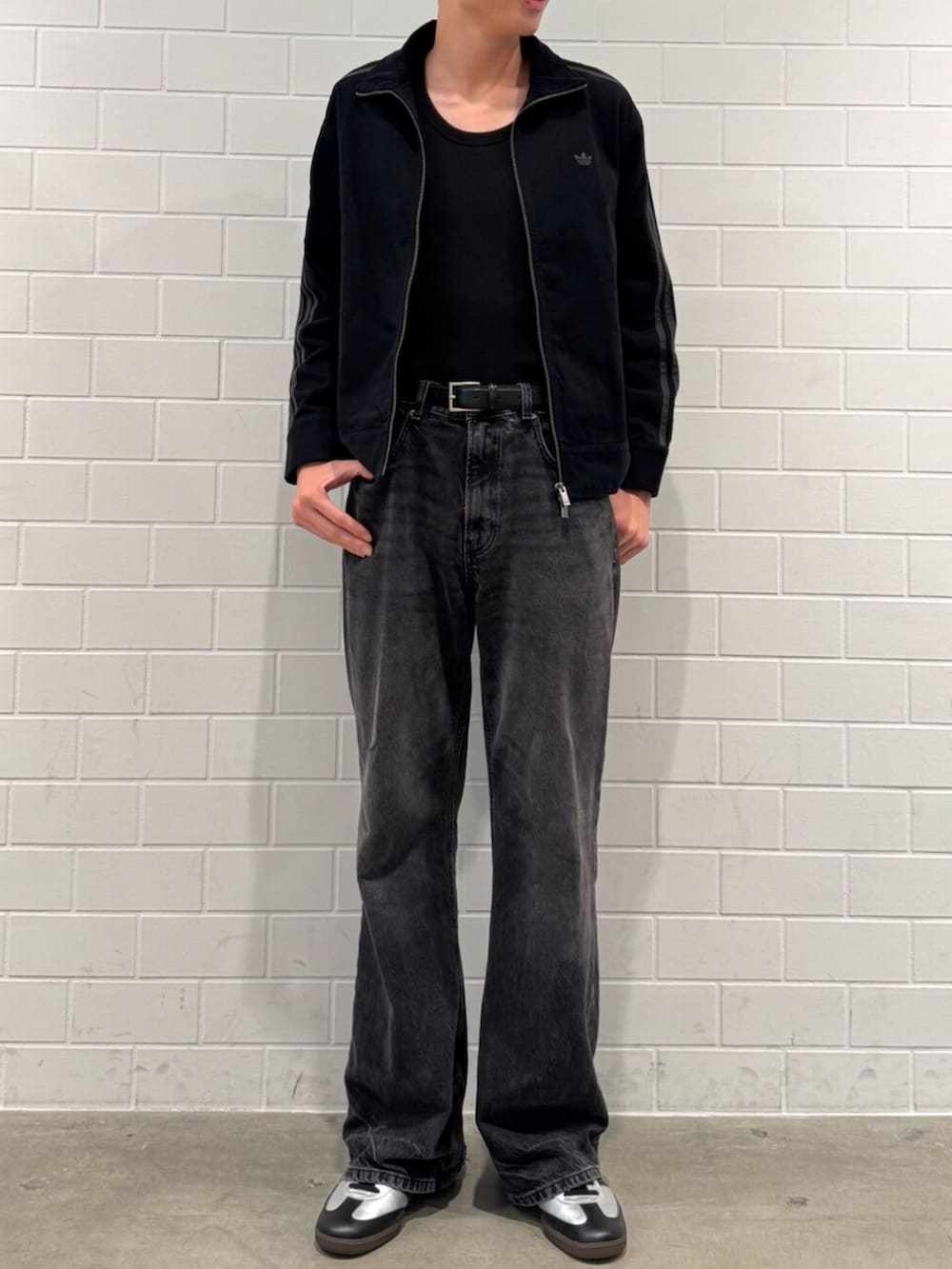 ブラック系のナイロンジャケット、シルバー系のスニーカーを着用したメンズの秋コーディネートの2枚目の写真