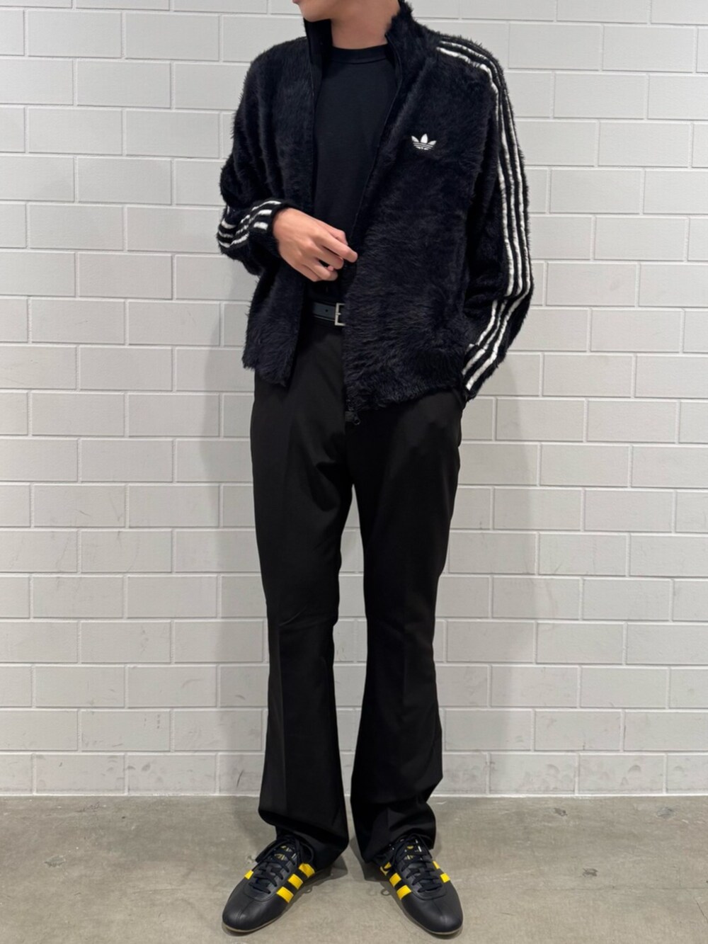 イエロー系のスニーカー、ブラック系のジャージを着用したメンズの秋コーディネートの2枚目の写真