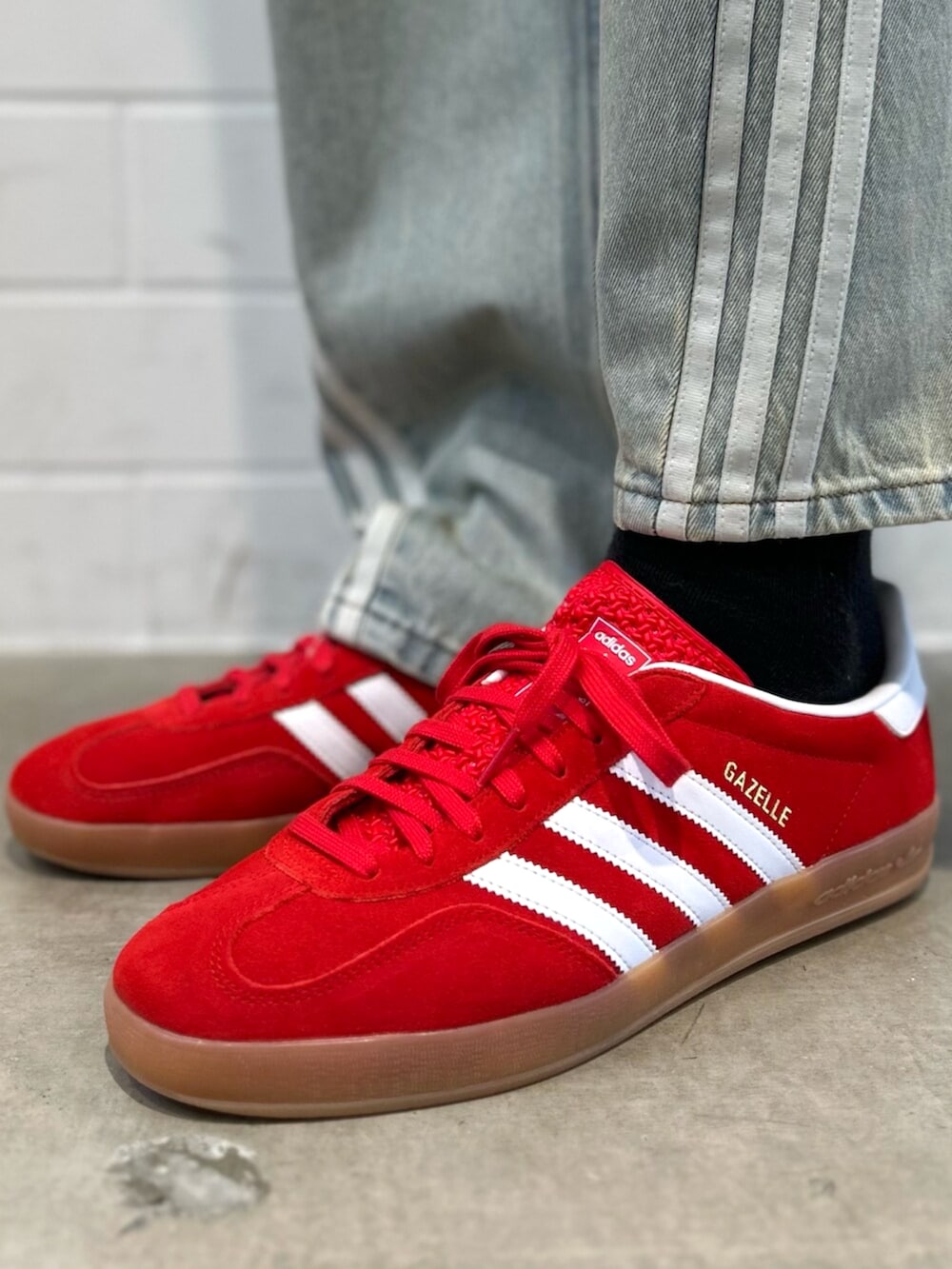 レッド系のシューズ、ブルー系のデニムパンツ、グレー系のスウェットを着用したメンズの秋コーディネートの6枚目の写真