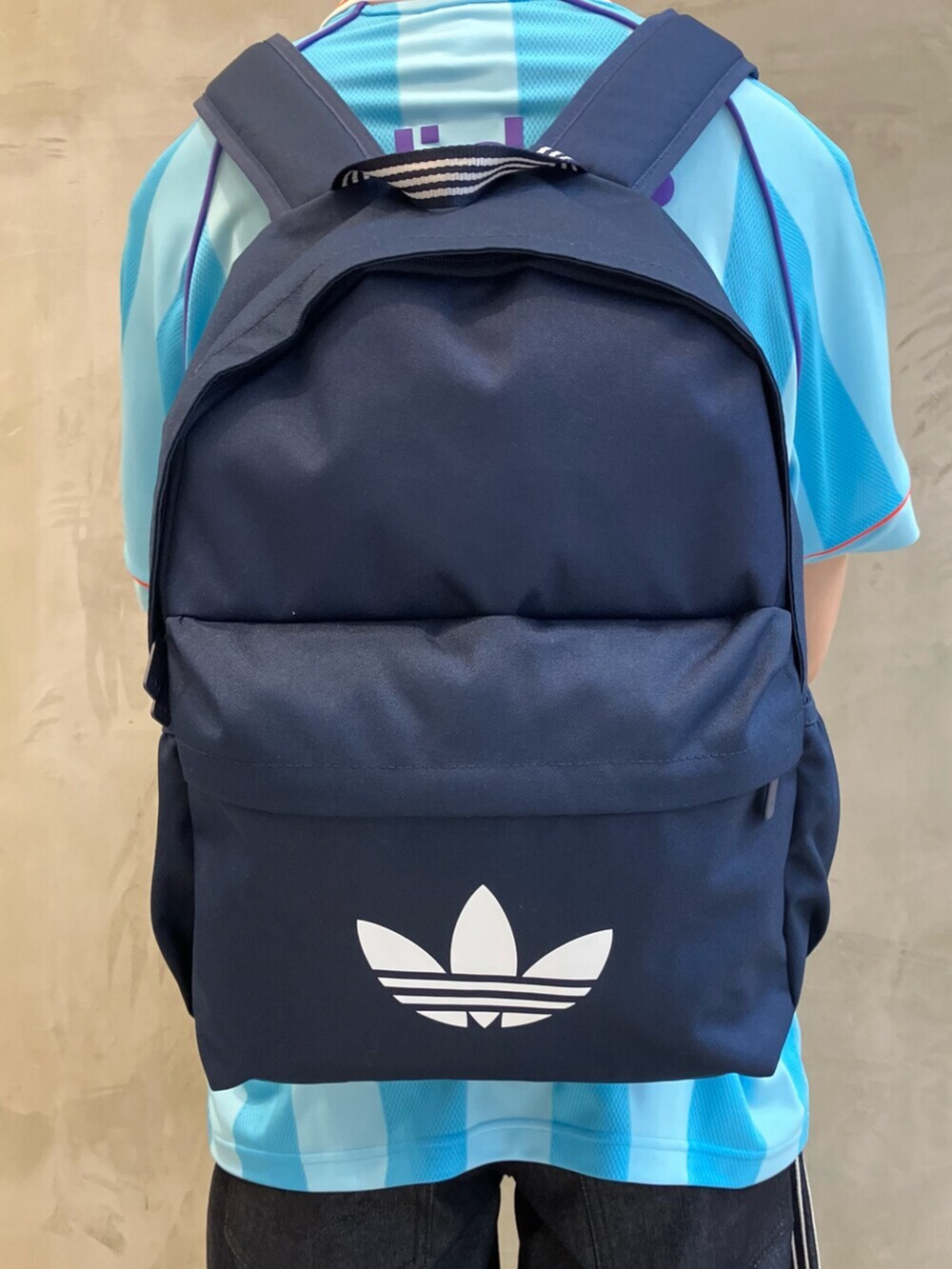 ブルー系のデニムパンツ、ブラック系のスニーカー、ブルー系のTシャツ/カットソーを着用したメンズの夏コーディネートの4枚目の写真