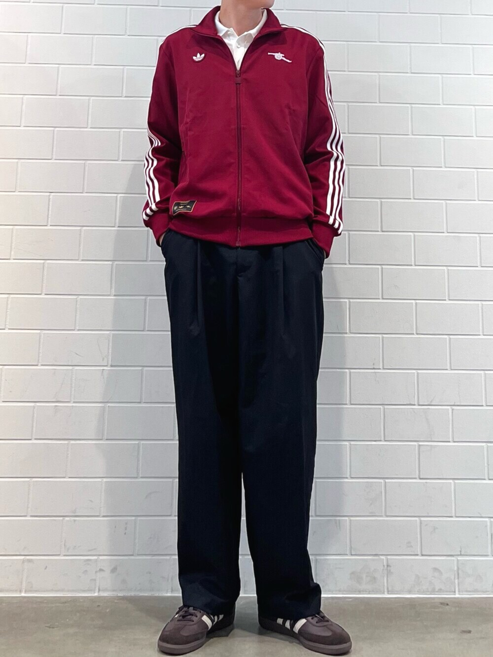 レッド系のジャージ、ホワイト系のポロシャツ、ブラウン系のスニーカーを着用したメンズの秋コーディネートの2枚目の写真