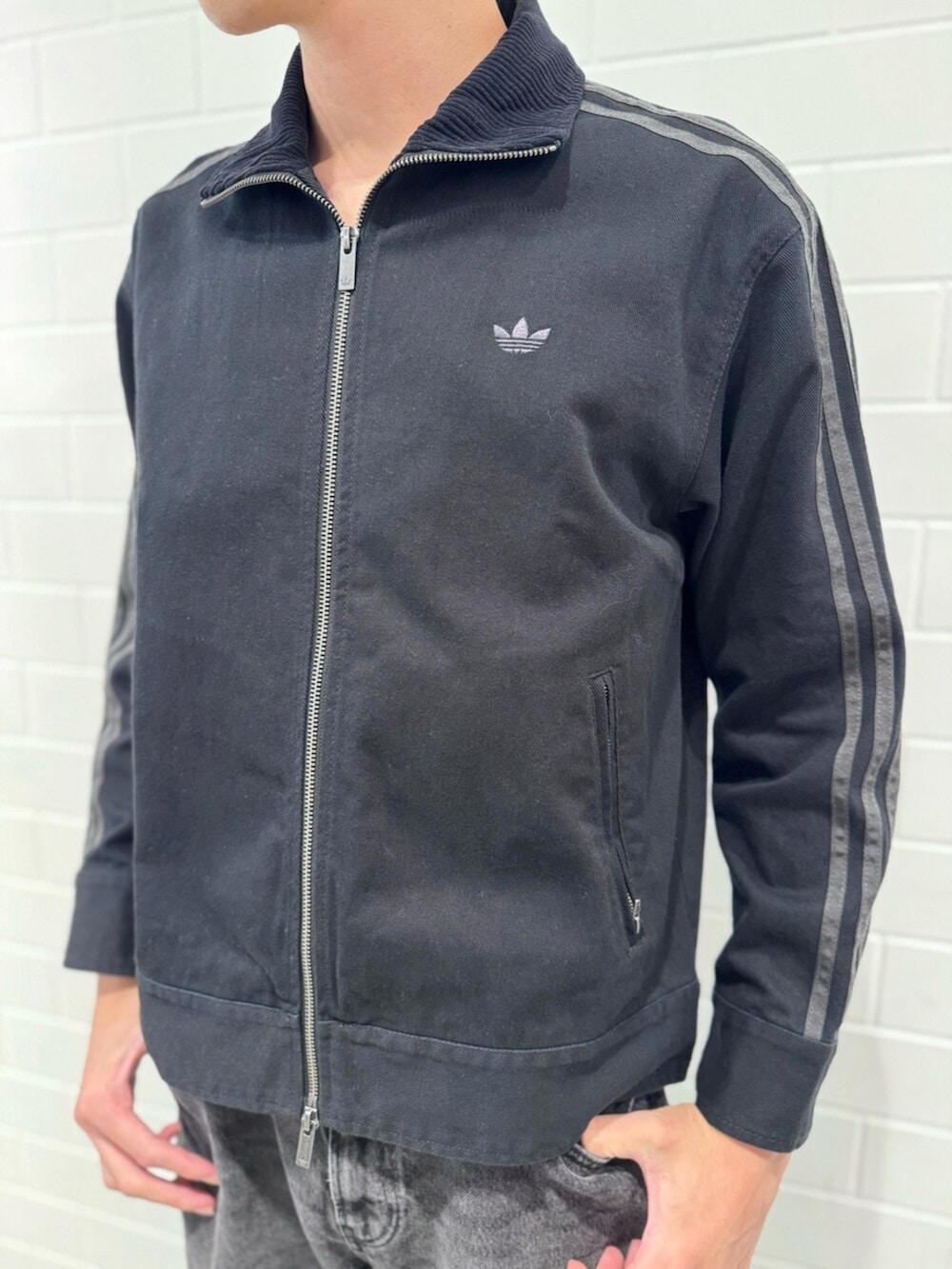 ブラック系のナイロンジャケット、シルバー系のスニーカーを着用したメンズの秋コーディネートの3枚目の写真