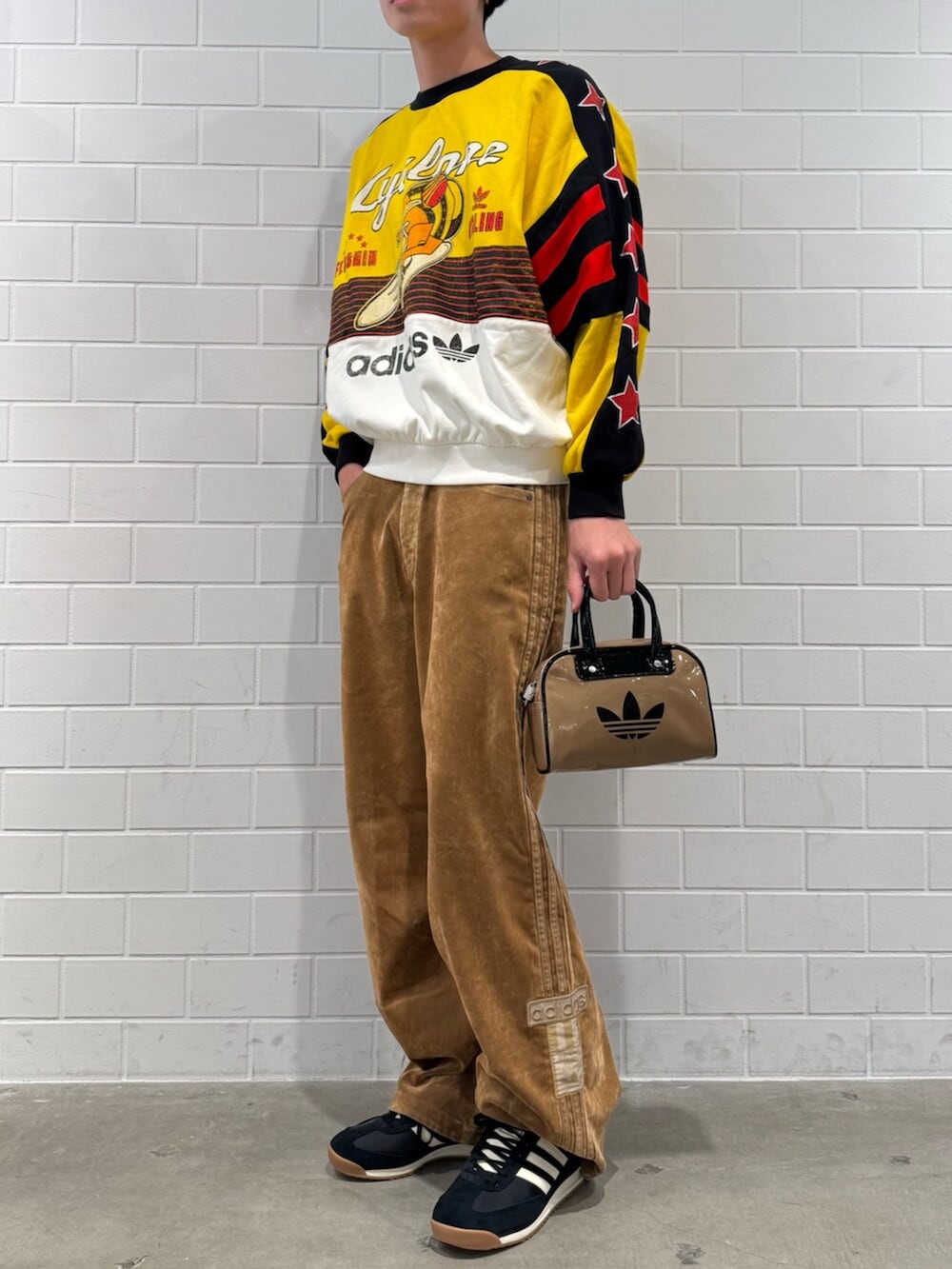 ベージュ系のショルダーバッグ、イエロー系のスウェット、ブラウン系のその他パンツを着用したメンズの秋コーディネートの2枚目の写真