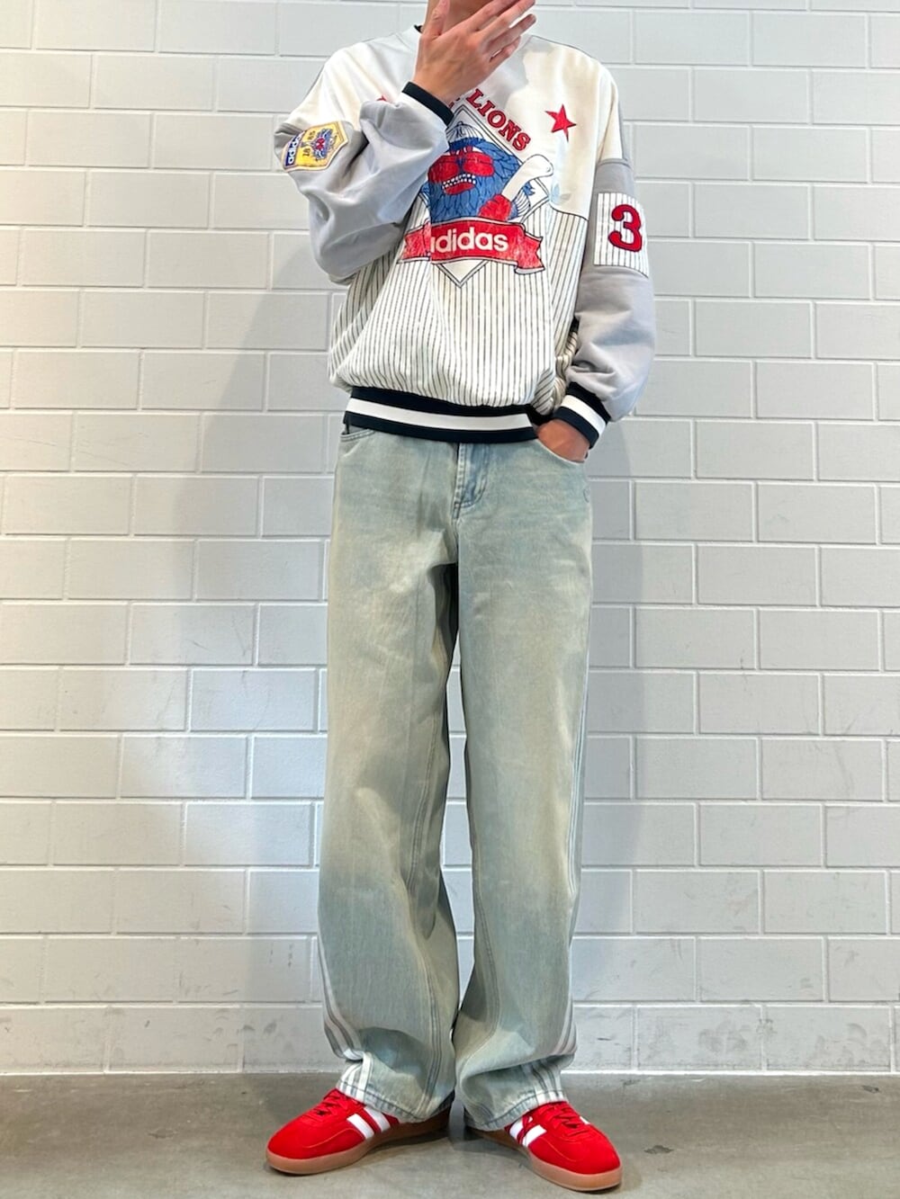 レッド系のシューズ、ブルー系のデニムパンツ、グレー系のスウェットを着用したメンズの秋コーディネートの2枚目の写真