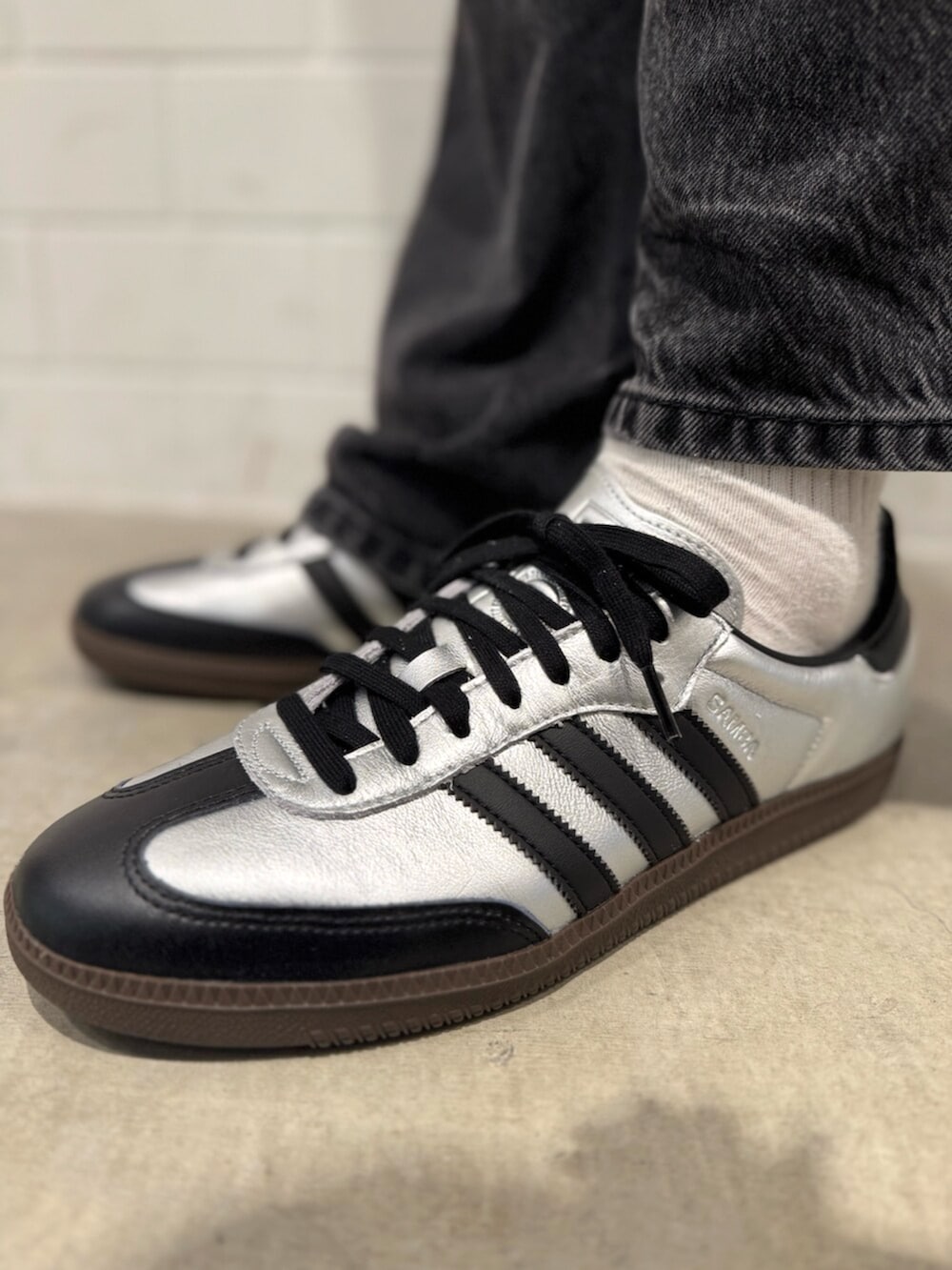 ブラック系のナイロンジャケット、シルバー系のスニーカーを着用したメンズの秋コーディネートの4枚目の写真