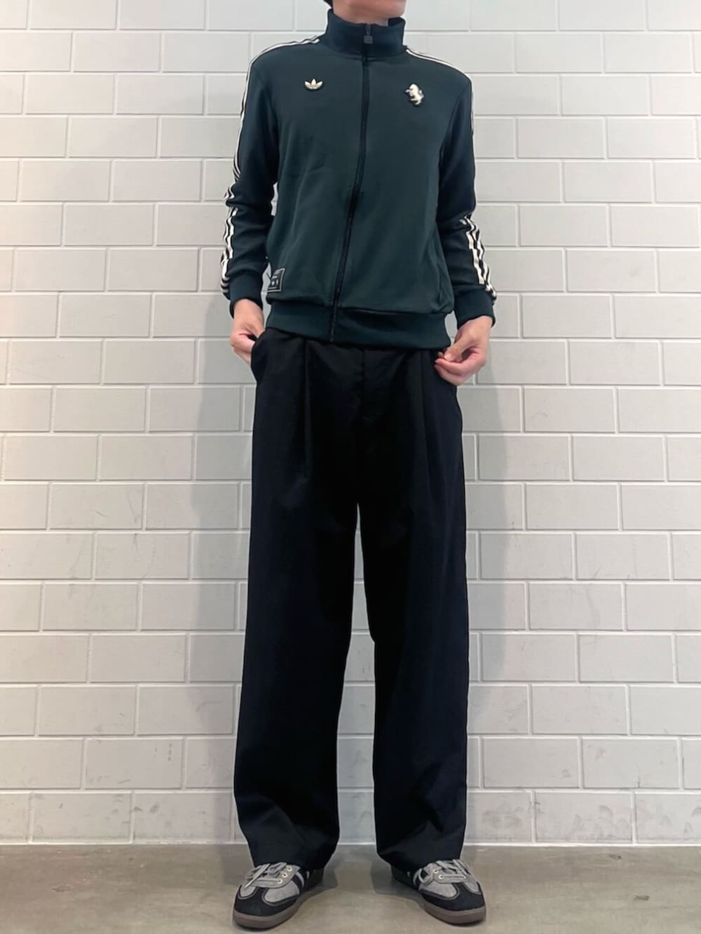 グリーン系のジャージ、ブラック系のTシャツ/カットソー、グレー系のスニーカーを着用したメンズの秋コーディネートの2枚目の写真