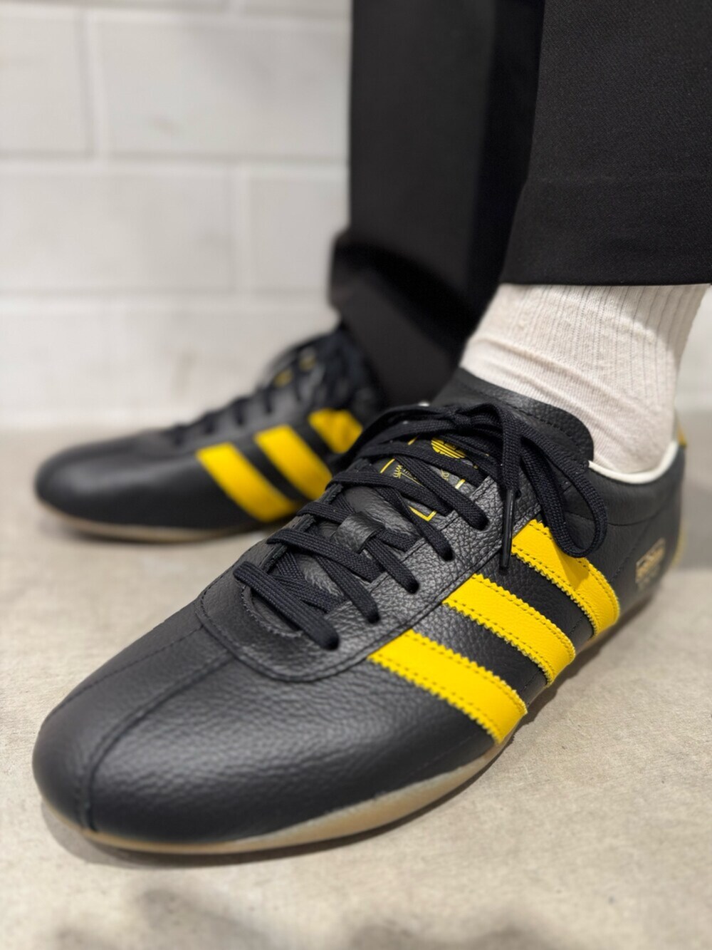 イエロー系のスニーカー、ブラック系のジャージを着用したメンズの秋コーディネートの4枚目の写真