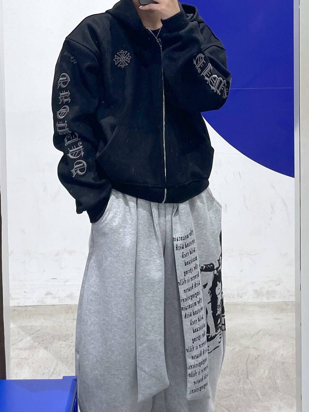 グレー系のスウェットパンツ、ブラック系のパーカーを着用したメンズの冬コーディネートの2枚目の写真