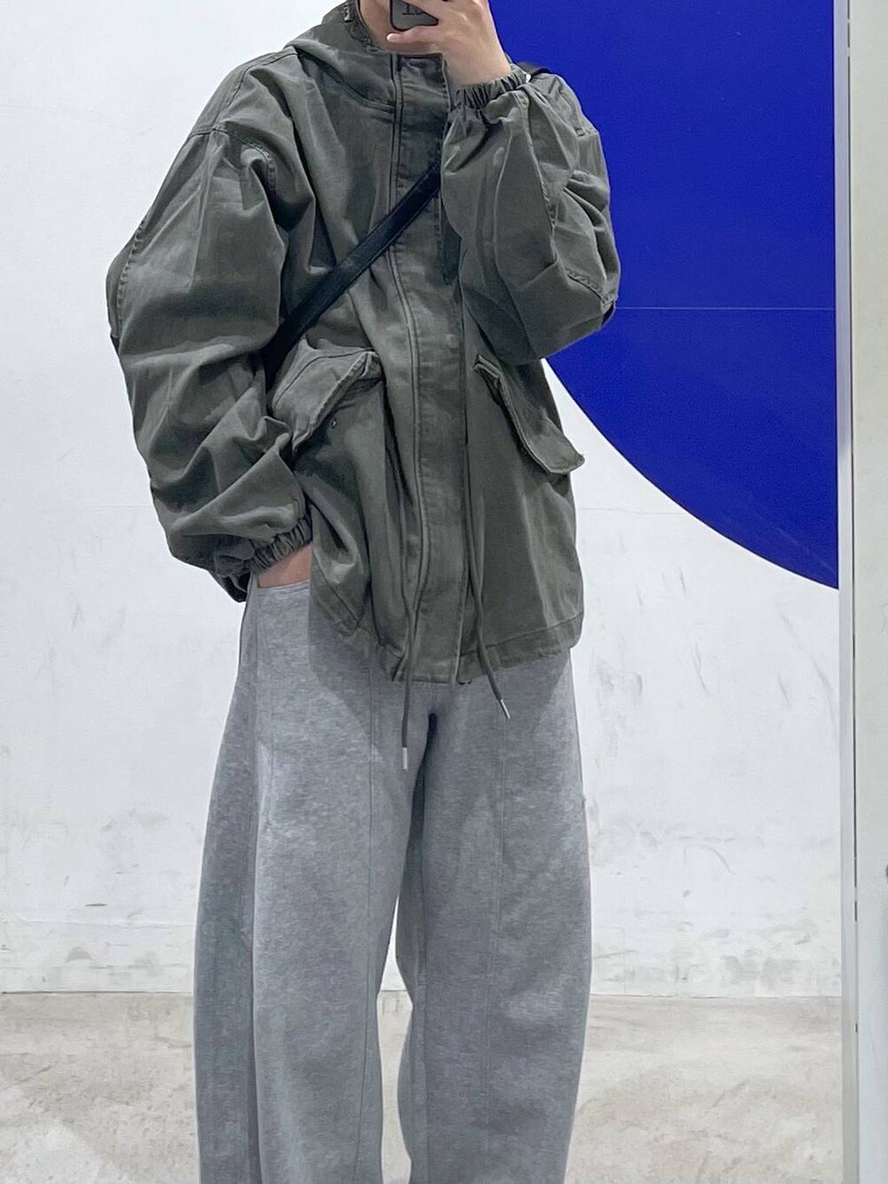 グリーン系のブルゾン、グレー系のスウェットパンツを着用したメンズの冬コーディネートの2枚目の写真