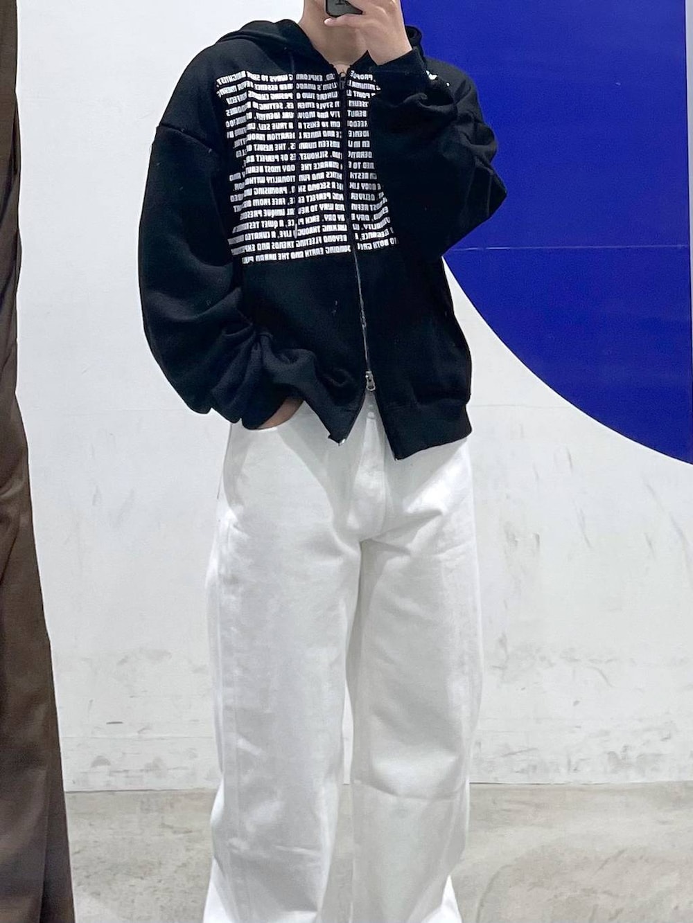 ブラック系のパーカー、ホワイト系のデニムパンツを着用したメンズの春コーディネートの2枚目の写真