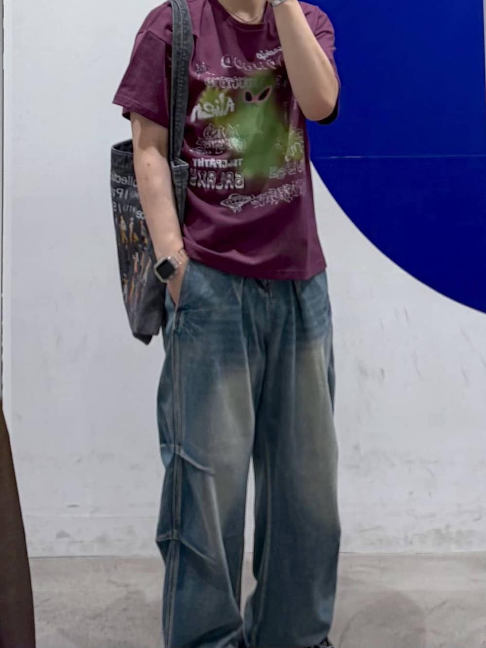 パープル系のTシャツ/カットソー、グレー系のトートバッグ、ブルー系のデニムパンツを着用したメンズの夏コーディネートの2枚目の写真