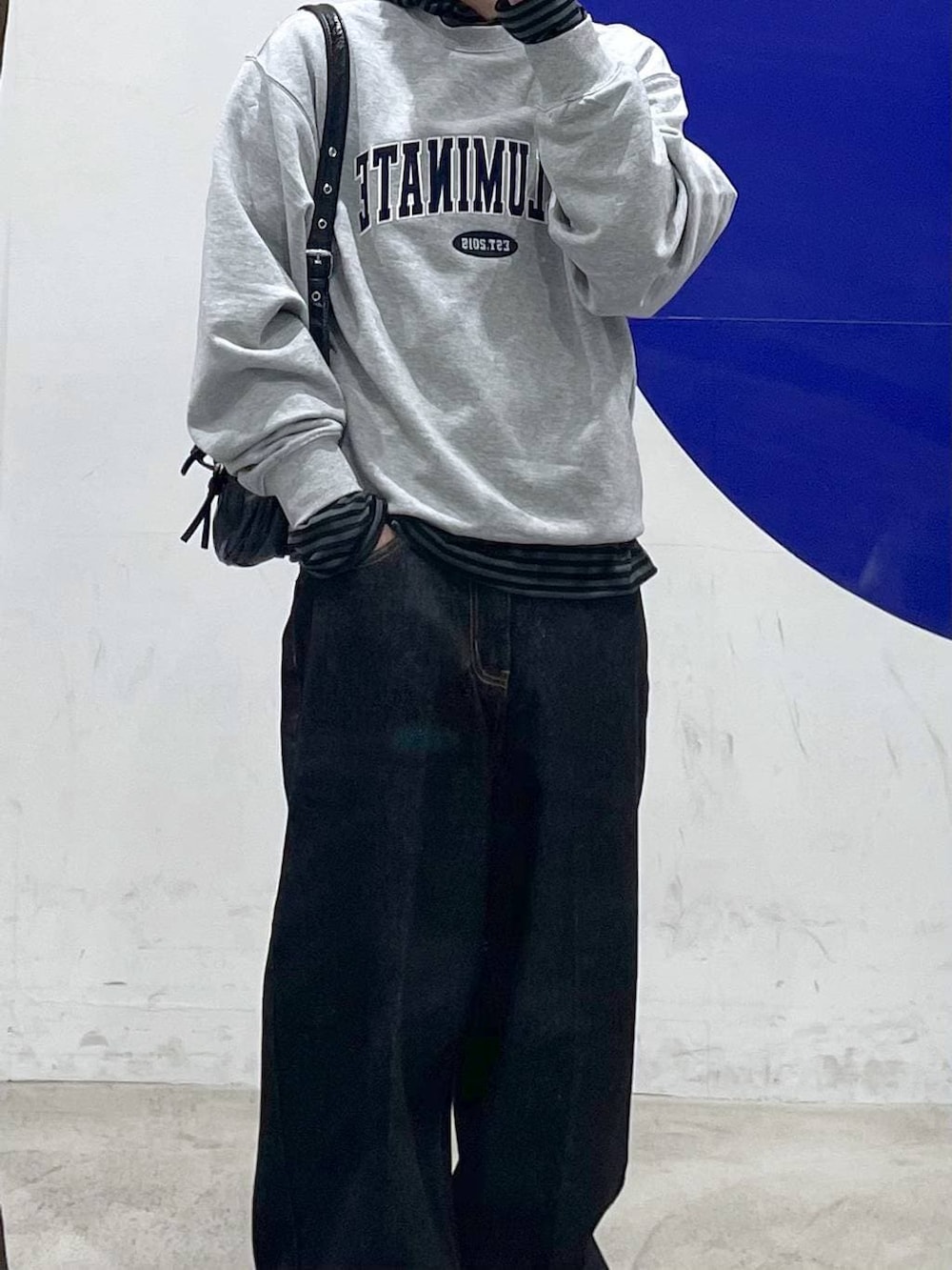 ブラック系のショルダーバッグ、グレー系のスウェット、ブラック系のデニムパンツを着用したメンズの春コーディネートの2枚目の写真