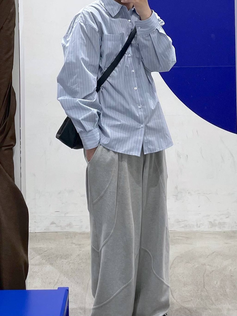 ブラック系のショルダーバッグ、グレー系のスウェットパンツ、ブルー系のシャツ/ブラウスを着用したメンズの冬コーディネートの2枚目の写真