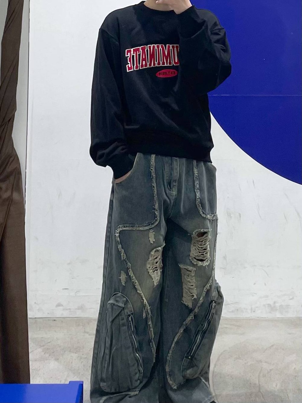 ブラック系のスウェット、ブルー系のデニムパンツを着用したメンズの春コーディネートの2枚目の写真