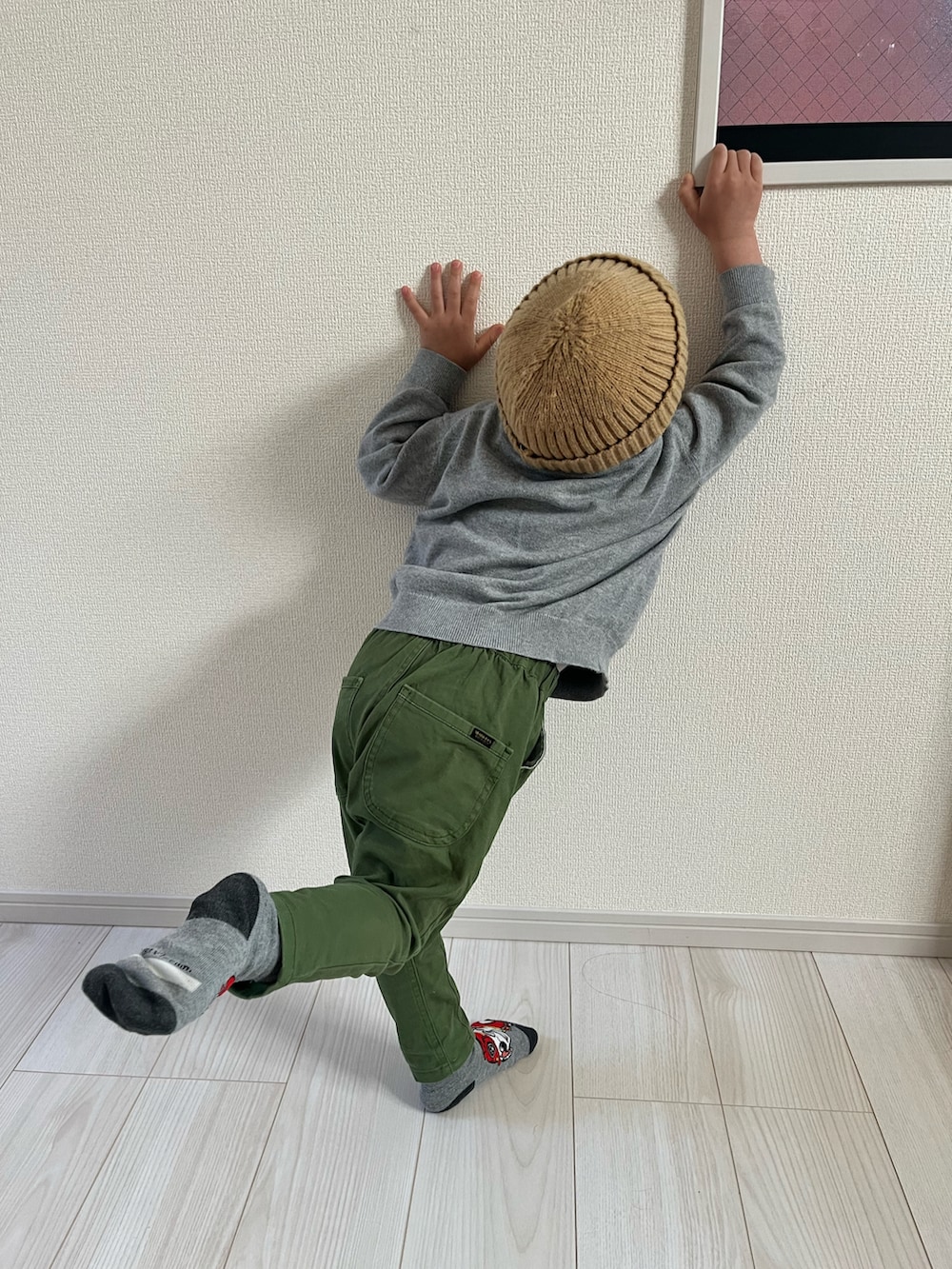 グレー系のニット/セーター、グリーン系のチノパンツ、ベージュ系のニットキャップ/ビーニーを着用したキッズの冬コーディネートの3枚目の写真