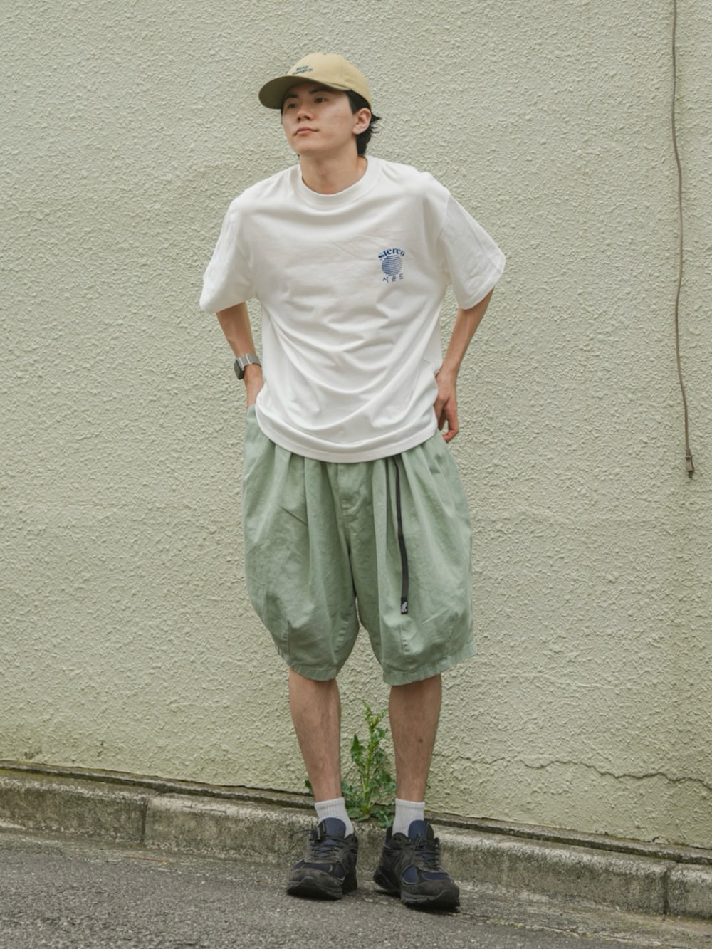グリーン系のパンツ、ホワイト系のTシャツ/カットソー、ブルー系のスニーカーを着用したメンズの夏コーディネートの3枚目の写真