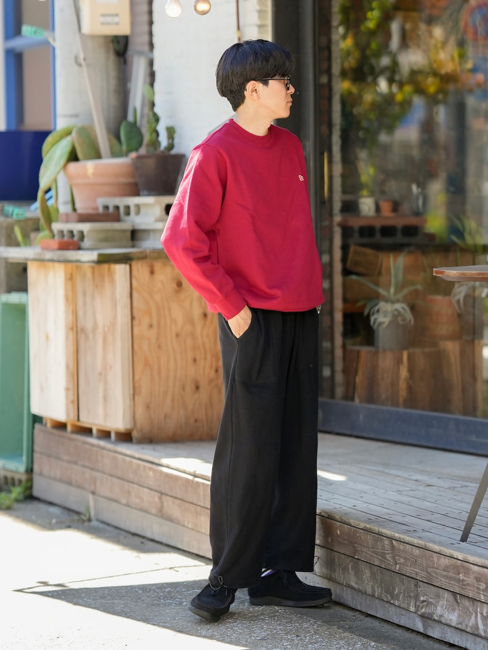 レッド系のスウェット、ブラック系のパンツ、ブラック系のモカシン/デッキシューズを着用したメンズの秋コーディネートの3枚目の写真