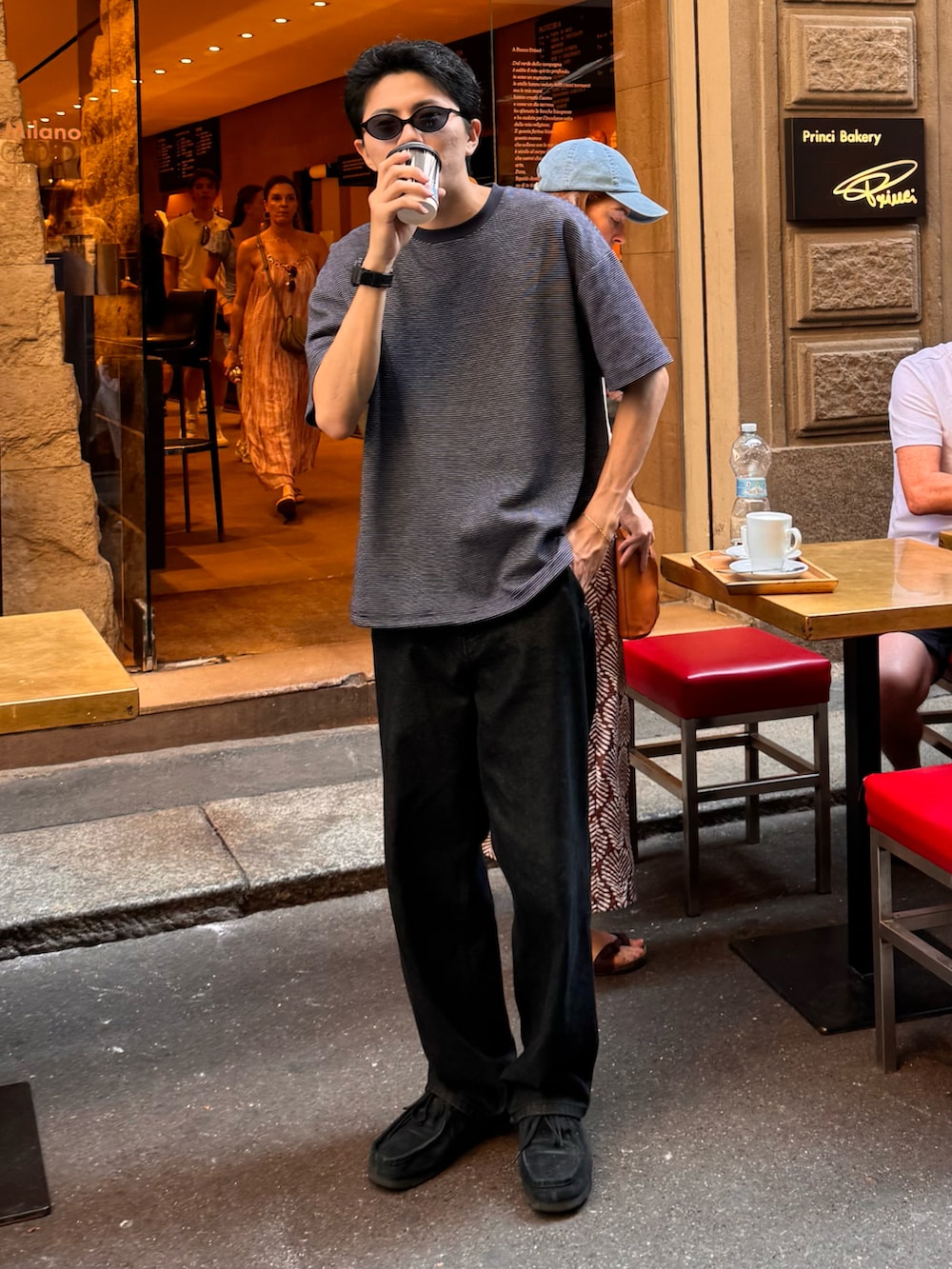 ブルー系のTシャツ/カットソー、ブラック系のパンツ、ブラック系のモカシン/デッキシューズを着用したメンズの夏コーディネートの2枚目の写真