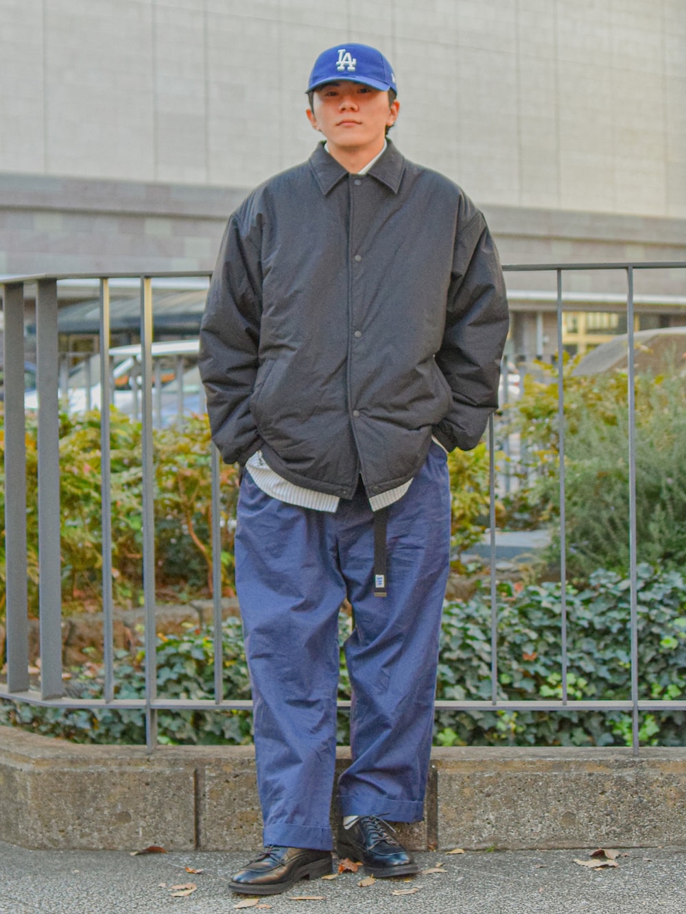 ブラック系のブルゾン、ブルー系のパンツ、ブラック系のドレスシューズを着用したメンズの冬コーディネートの3枚目の写真