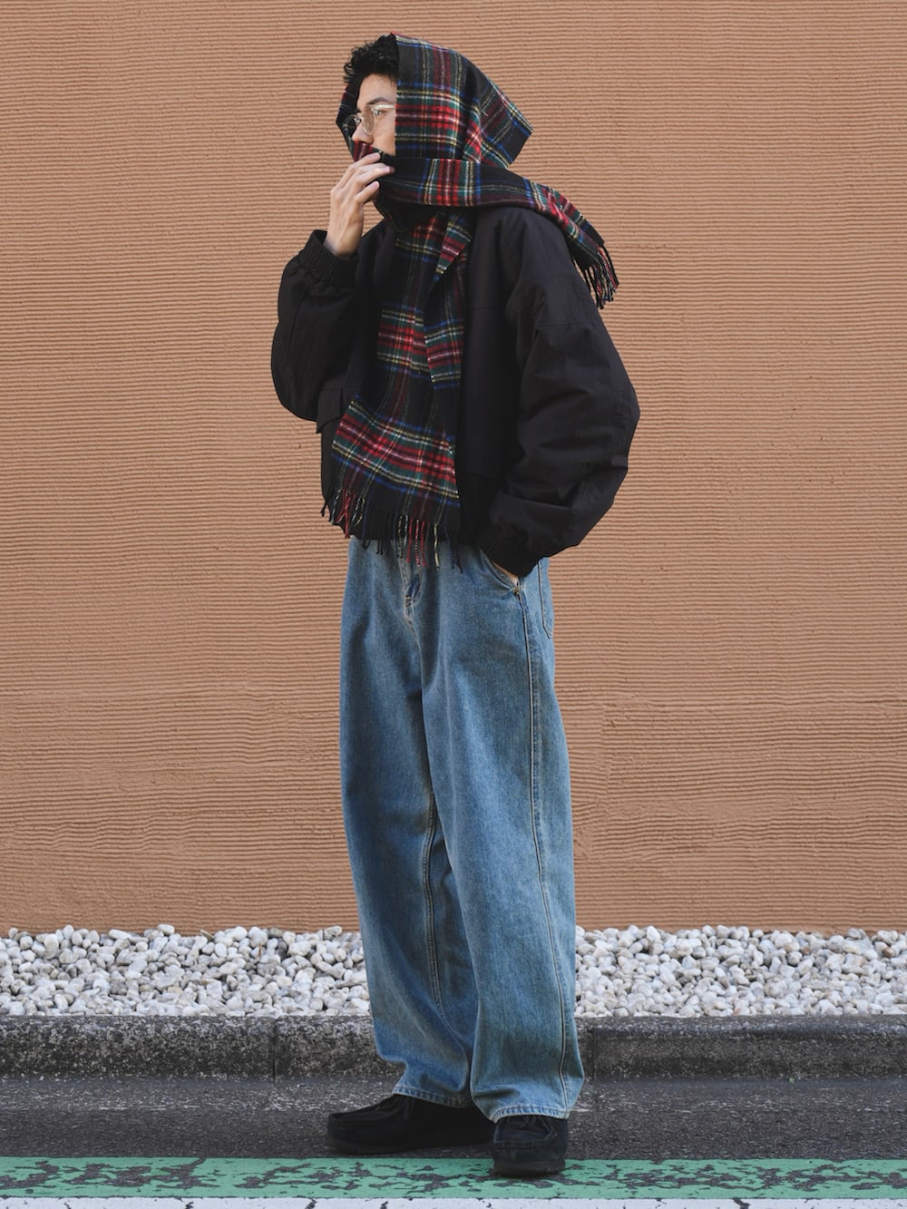 ブラック系のミリタリージャケット、ブルー系のデニムパンツ、ブラック系のモカシン/デッキシューズを着用したメンズの冬コーディネートの3枚目の写真