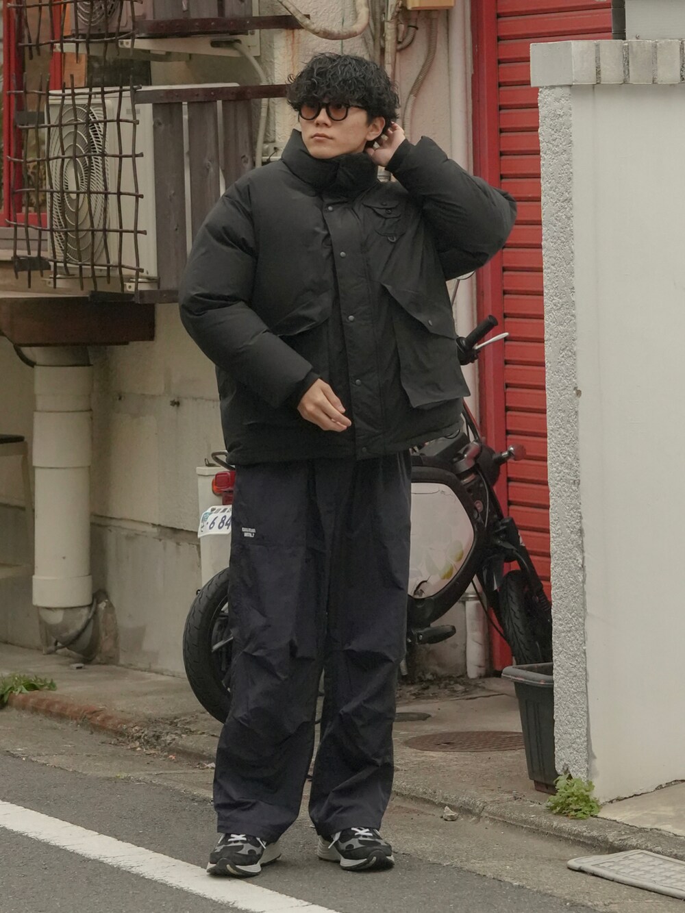 ブラック系のダウンジャケット/コート、ブラック系のパンツ、ブラック系のスニーカーを着用したメンズの冬コーディネートの3枚目の写真