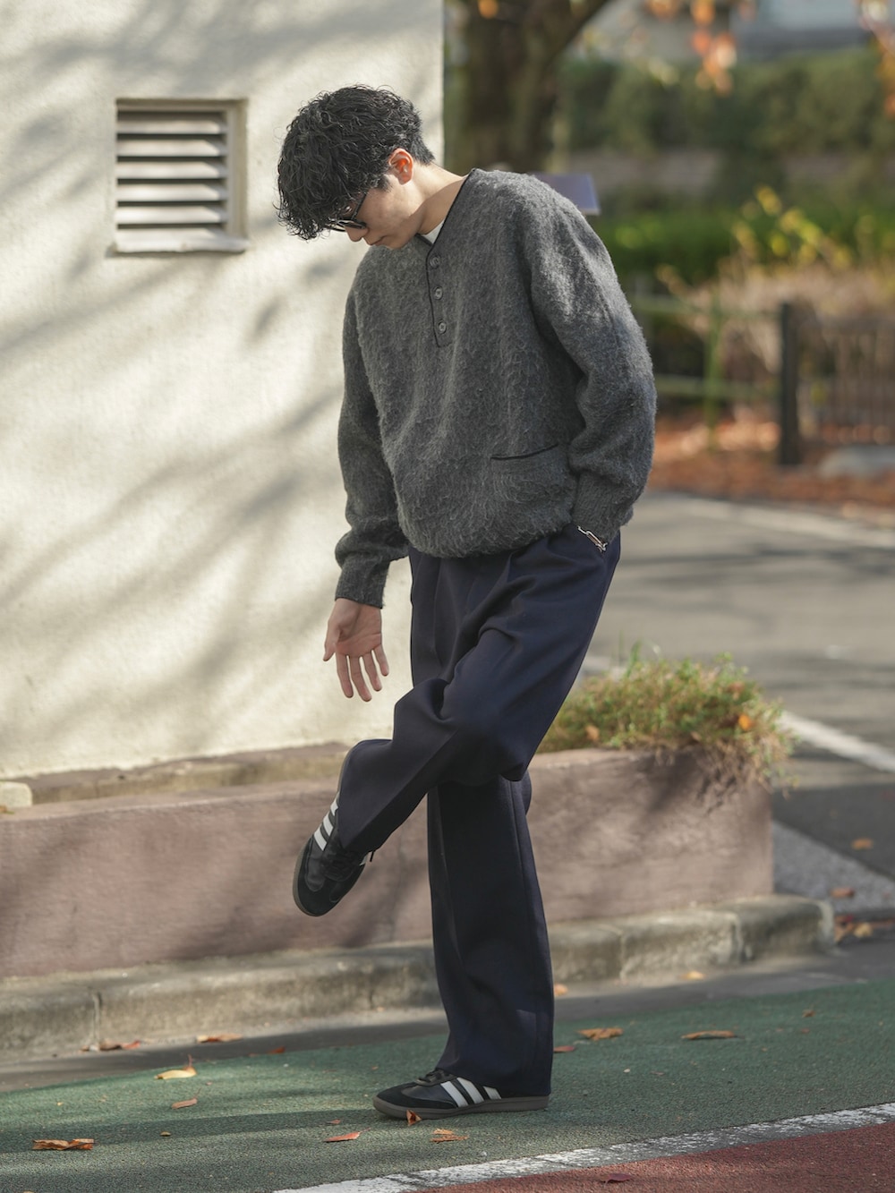 グレー系のニット/セーター、ブルー系のスラックス、ブラック系のスニーカーを着用したメンズの冬コーディネートの3枚目の写真