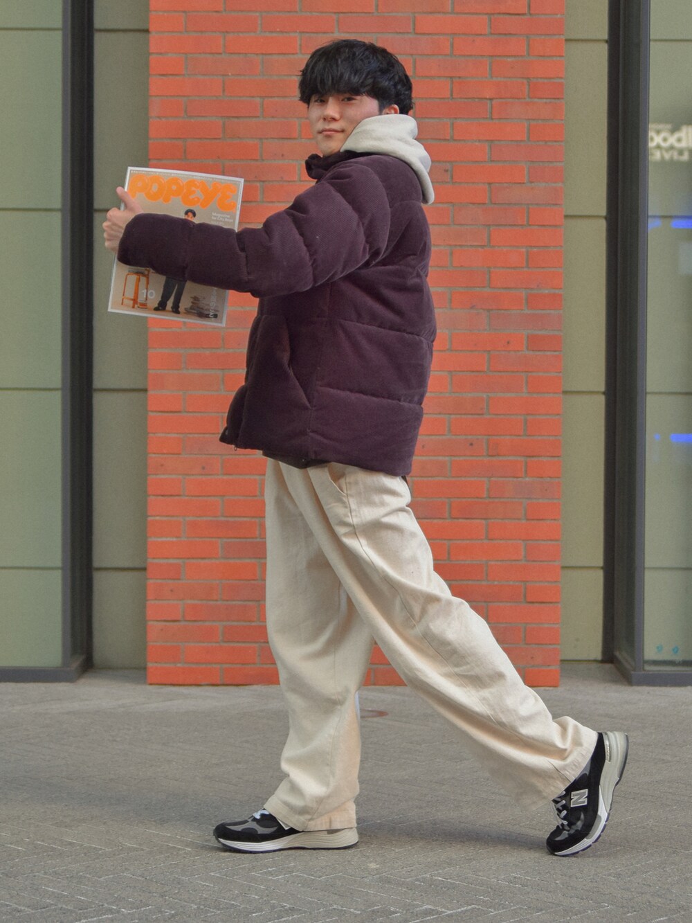 ホワイト系のデニムパンツ、ブラウン系のダウンジャケット/コート、ベージュ系のパーカーを着用したメンズの冬コーディネートの2枚目の写真