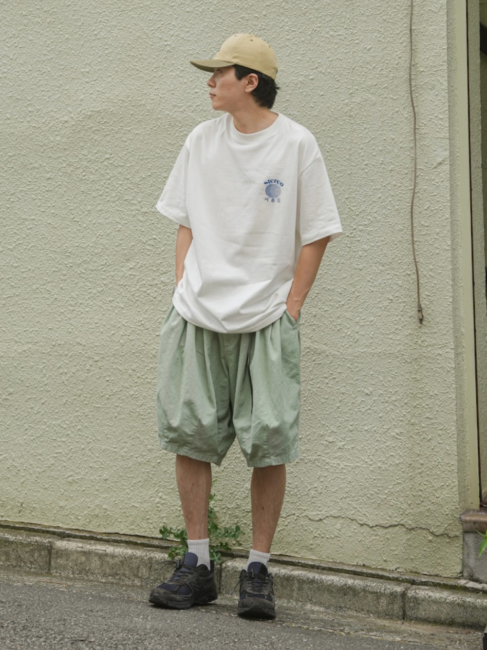 グリーン系のパンツ、ホワイト系のTシャツ/カットソー、ブルー系のスニーカーを着用したメンズの夏コーディネートの2枚目の写真