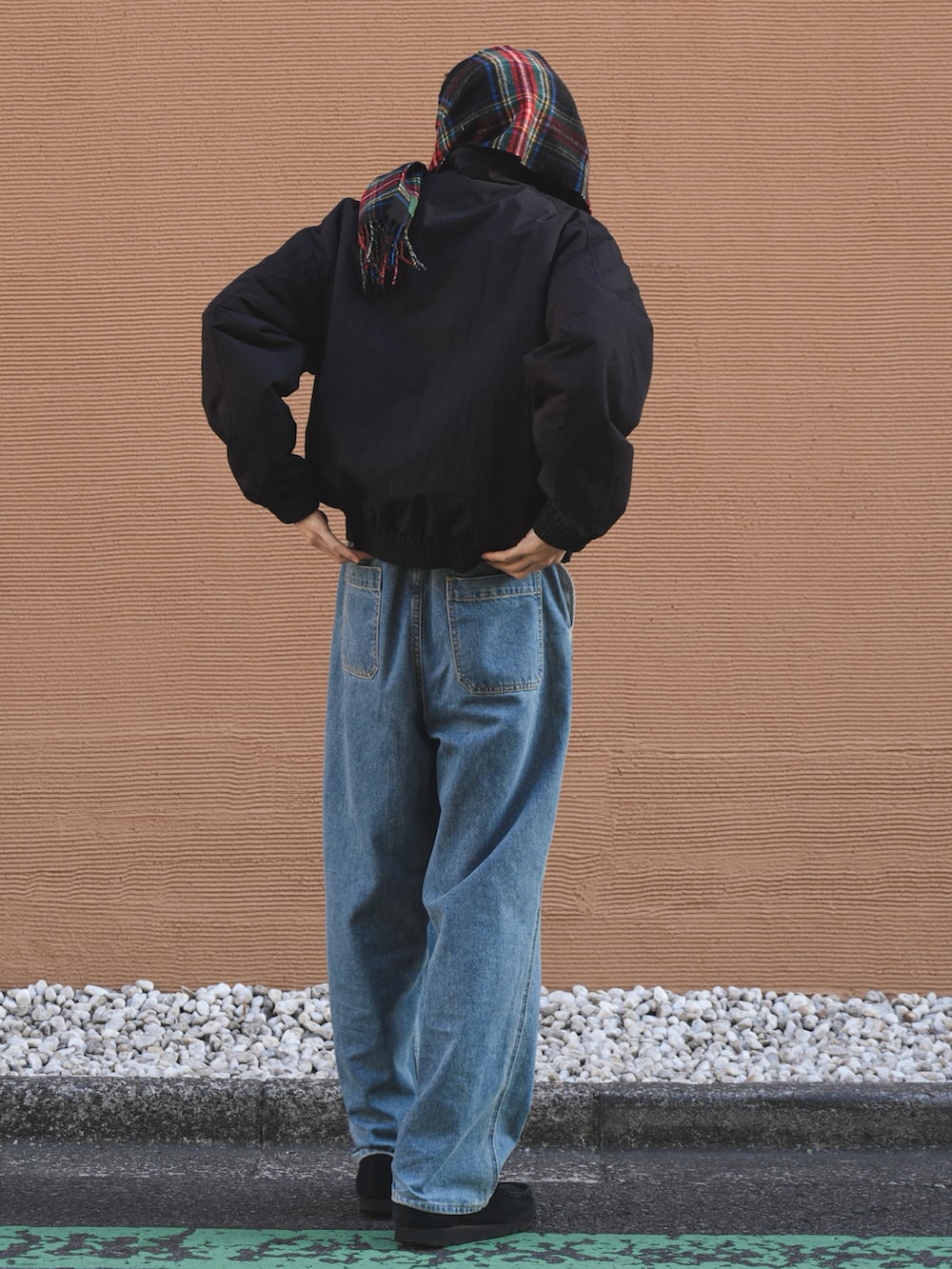 ブラック系のミリタリージャケット、ブルー系のデニムパンツ、ブラック系のモカシン/デッキシューズを着用したメンズの冬コーディネートの2枚目の写真